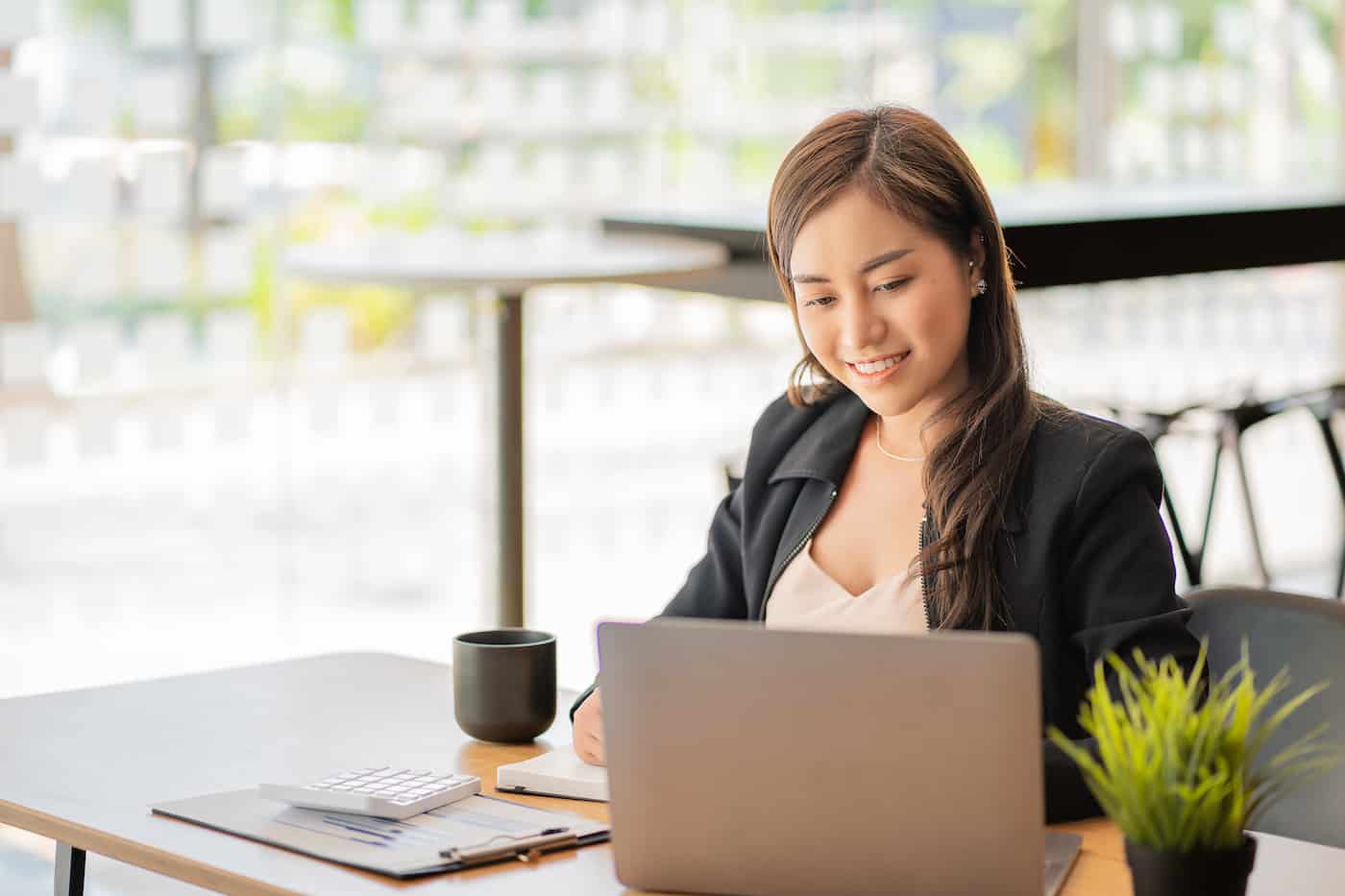 a woman sitting at a table in front of a laptop