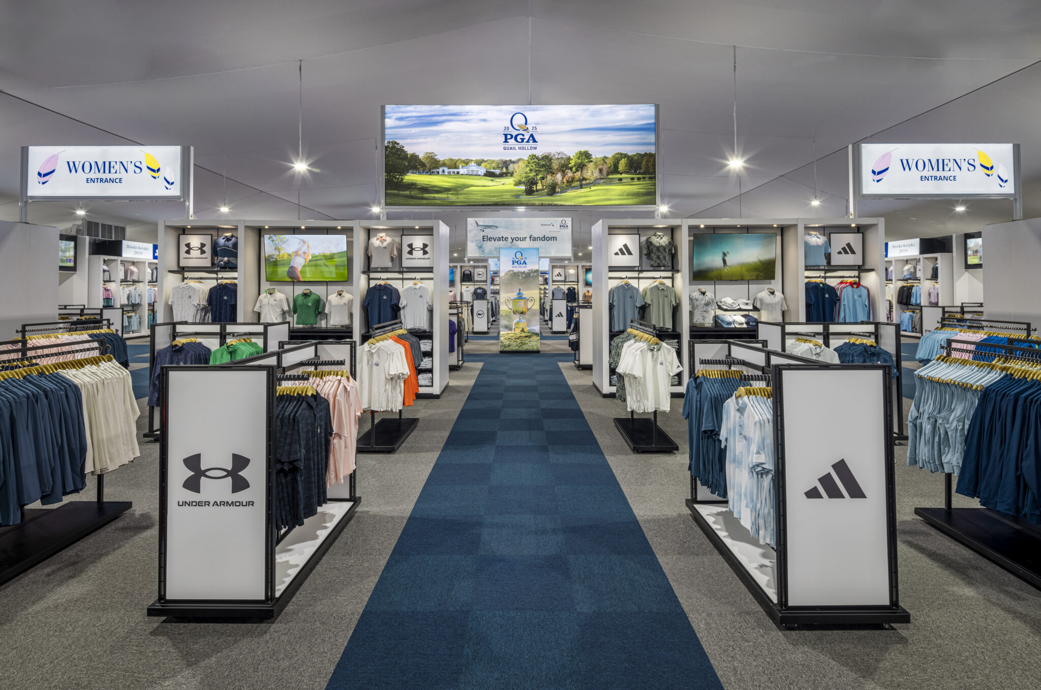 Blue runway carpet down the middle of a large merchandise tent