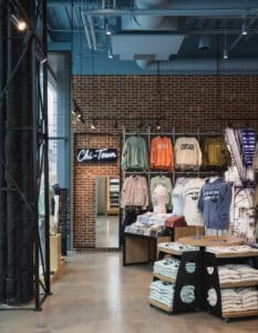 wall unit of womens shirt in front of brick wall
